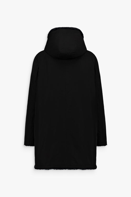 Manteau ébène avec fourrure bleu nuit d’un côté et matière lisse de l’autre, coupe droite et cordons bijoux.