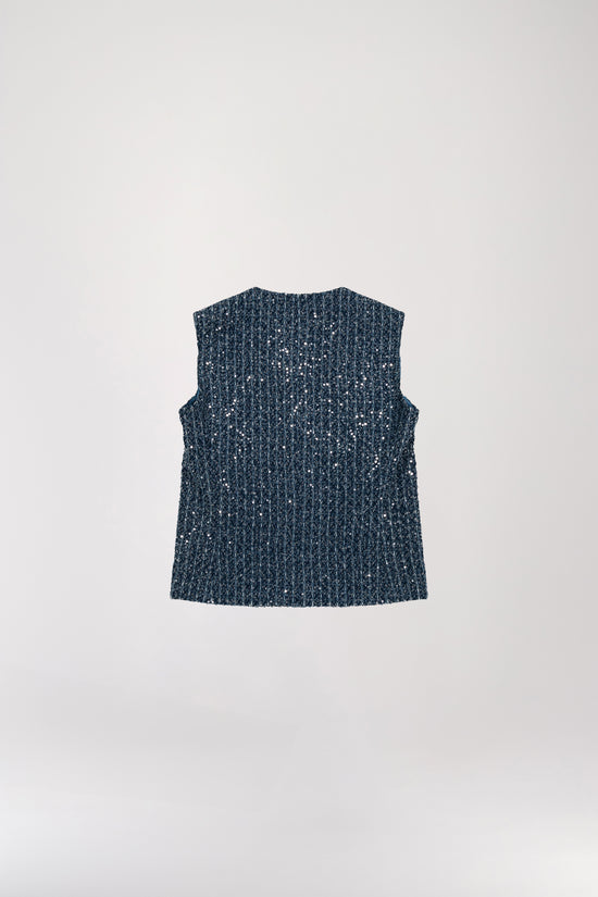 Modèle portant un gilet à sequins bleu denim scintillants, avec un col en V qui sublime votre port de tête. Doté de subtiles fentes latérales et d’un tissu léger et agréable, il offre une coupe sans manches élégante.