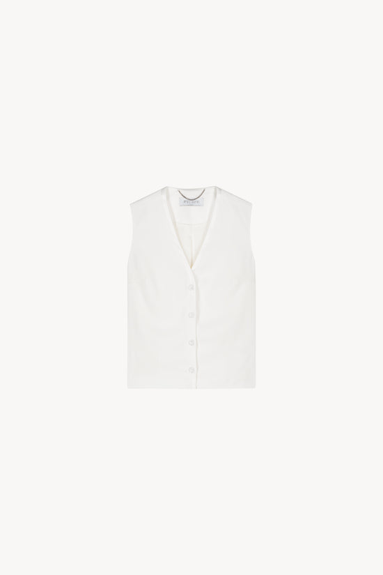 Ce gilet sans manche blanc cassée avec un col en V et ses boutons recouverts .