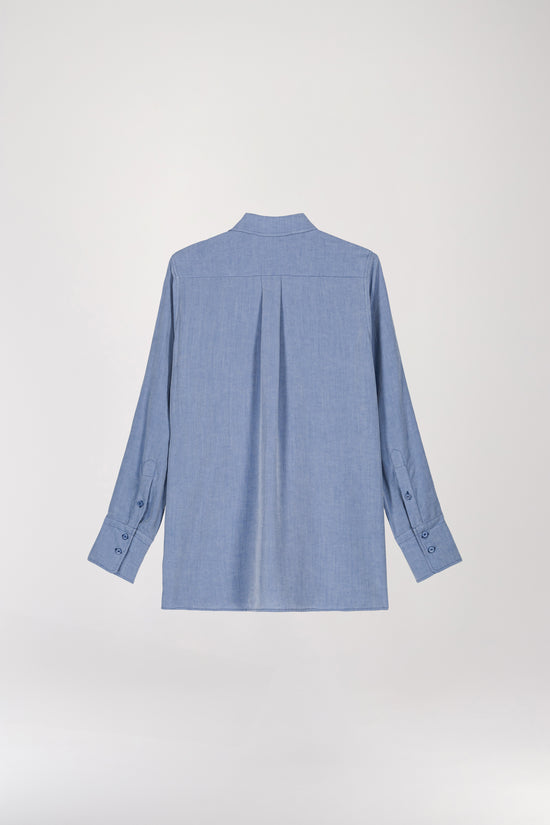 Chemise en lin brodée bleu denim, alliant design minimaliste et sophistication. Sa coupe ajustée flatte la silhouette tout en offrant une allure décontractée, idéale pour un style élégant sans effort. Dotée d’un col revers pointu, d’une broderie aux épaules, d’un boutonnage apparent et de boutons nacrés, elle se démarque par ses détails raffinés.