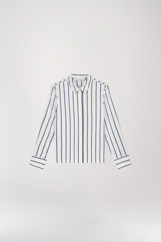 Chemise courte rayées marine taillée dans une coupe courte et droite, se distinguant par ses rayures minimalistes dans une teinte bleue marine, un col chemise, une patte de boutonnage cachée et des manches longues.