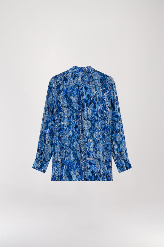 Chemise fluide à imprimé python bleu, confectionnée en tissu léger pour un confort optimal. Dotée d'une patte de boutonnage apparente avec des boutons nacrés élégants, elle allie douceur et sophistication, offrant une élégance intemporelle et soignée.