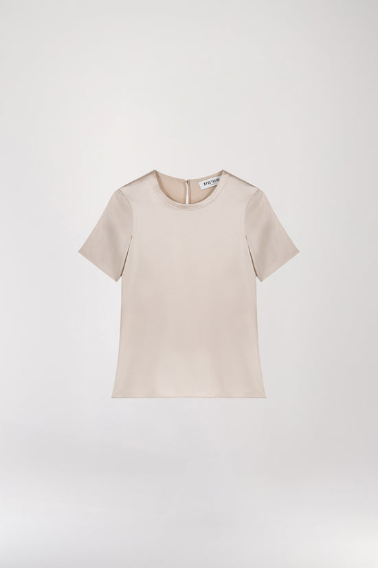 T-shirt en soie or mat, minimaliste et au look élégant, conçu pour sublimer votre style sans effort. Doté d’un col rond, de manches courtes, d’une fermeture à bouton dans le dos et d’une forme goutte avec bouton recouvert, il allie sophistication et simplicité.