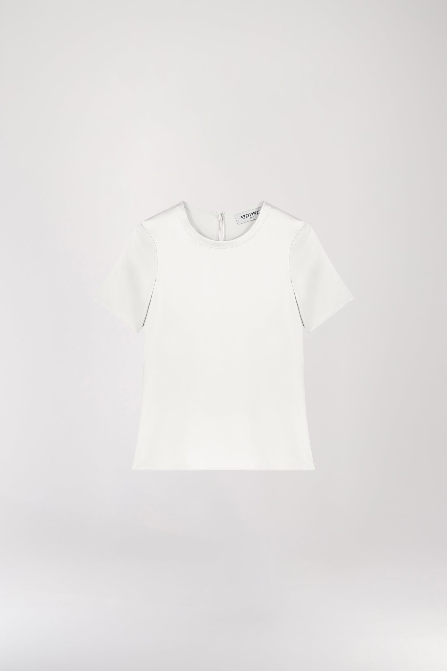 T-shirt en soie blanc, minimaliste et au look soyeux, parfait pour élever votre style sans effort. Il présente un col rond, des manches courtes, une fermeture à bouton dans le dos et une forme goutte avec un bouton recouvert, alliant élégance et simplicité.