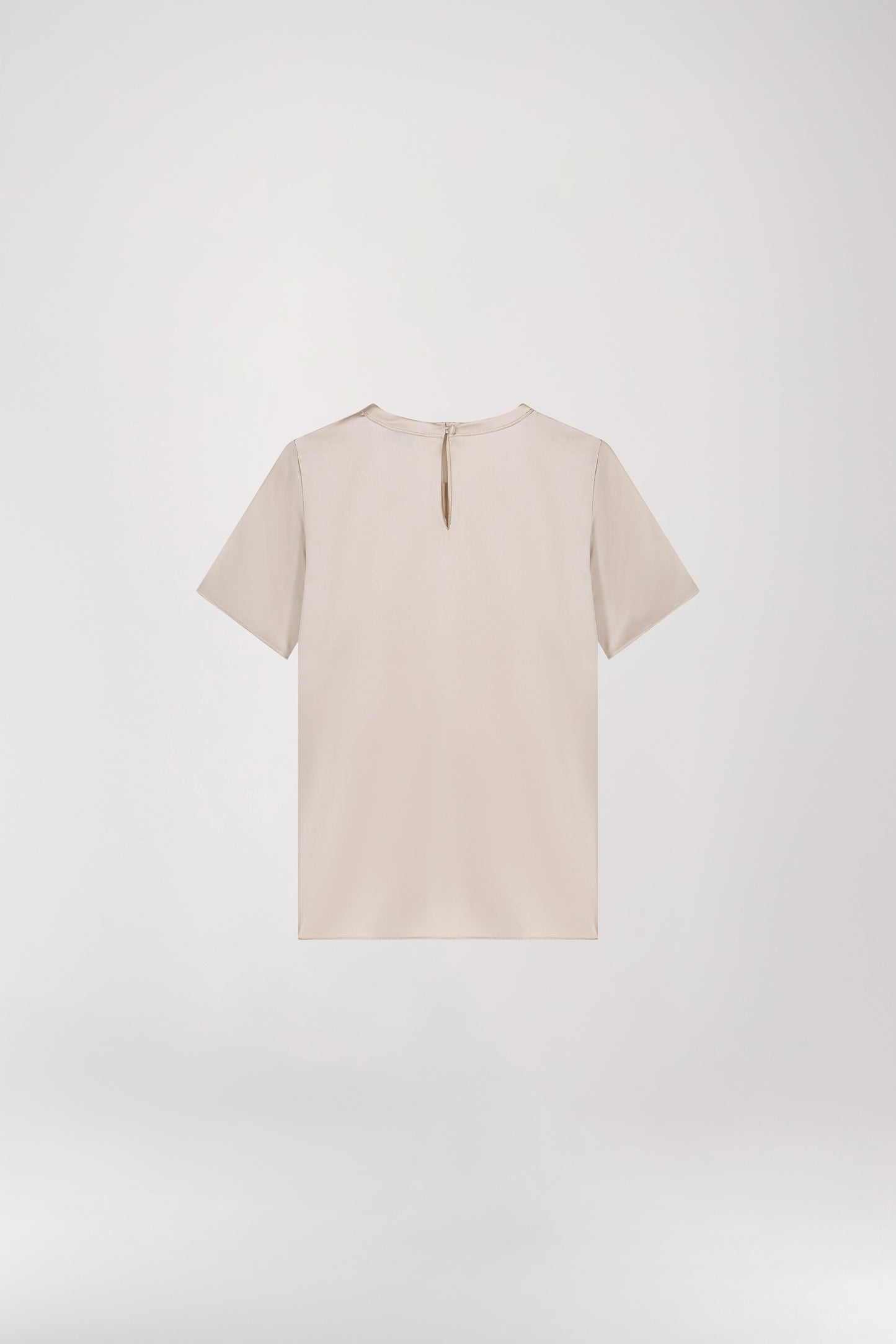 T-shirt en soie or mat, minimaliste et au look élégant, conçu pour sublimer votre style sans effort. Doté d’un col rond, de manches courtes, d’une fermeture à bouton dans le dos et d’une forme goutte avec bouton recouvert, il allie sophistication et simplicité.