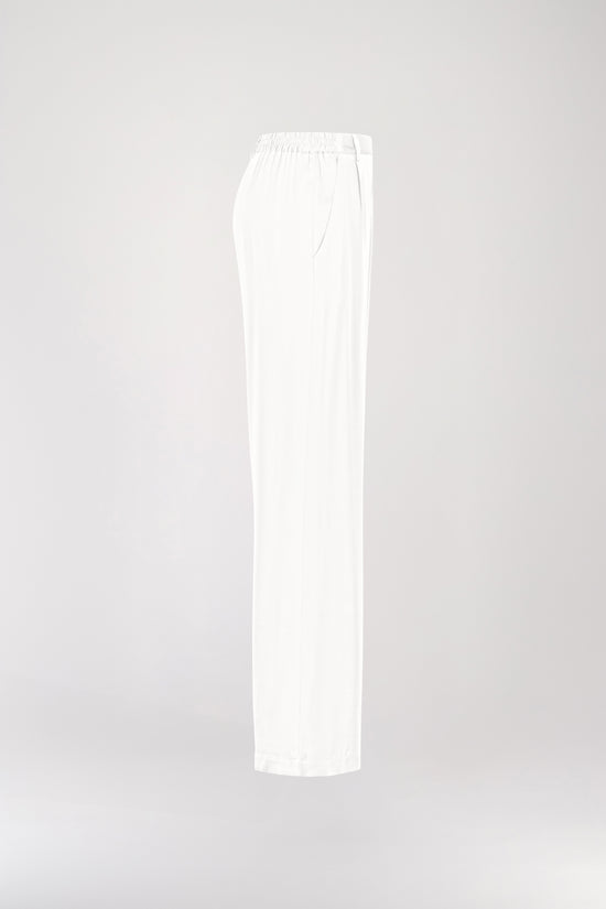 Pantalon en soie blanc, avec une coupe droite et fluide qui souligne élégamment votre silhouette. Sa taille ajustée assure un confort optimal, tandis que les plis de presse marqués, les passants de ceinture et les revers aux chevilles ajoutent une touche sophistiquée.