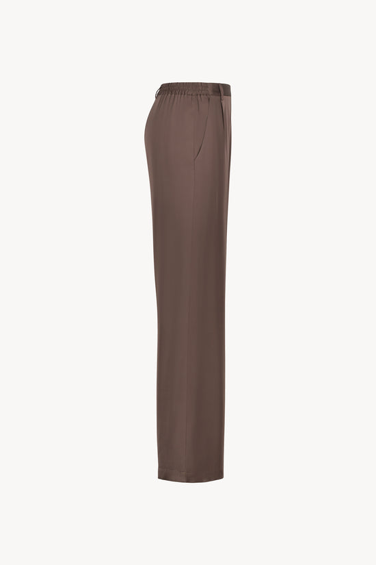Pantalon en soie taupe moyen, avec une coupe droite et fluide qui souligne élégamment votre silhouette. Sa taille ajustée assure un confort optimal, tandis que les plis de presse marqués, les passants de ceinture et les revers aux chevilles ajoutent une touche sophistiquée.