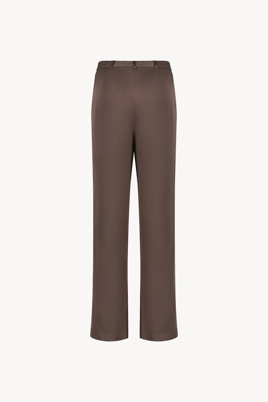 Pantalon en soie taupe moyen, avec une coupe droite et fluide qui souligne élégamment votre silhouette. Sa taille ajustée assure un confort optimal, tandis que les plis de presse marqués, les passants de ceinture et les revers aux chevilles ajoutent une touche sophistiquée.