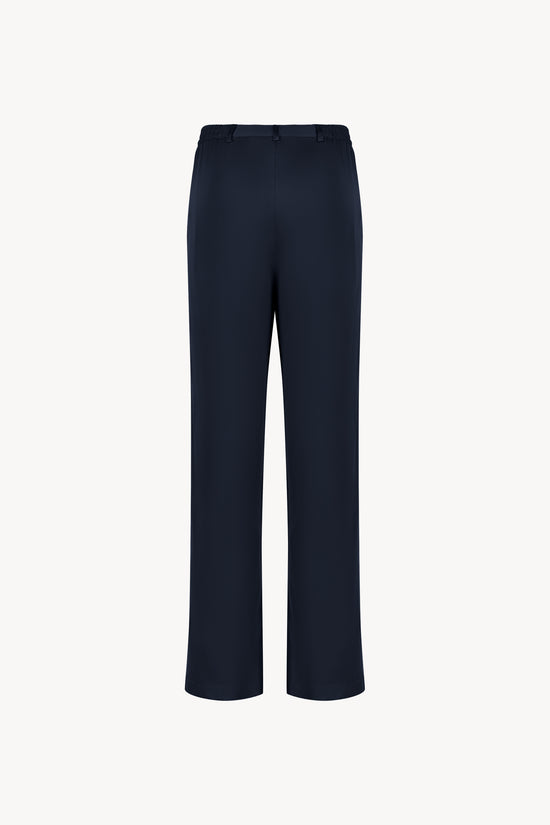 Pantalon en soie marine, avec une coupe droite et fluide qui souligne élégamment votre silhouette. Sa taille ajustée assure un confort optimal, tandis que les plis de presse marqués, les passants de ceinture et les revers aux chevilles ajoutent une touche sophistiquée.
