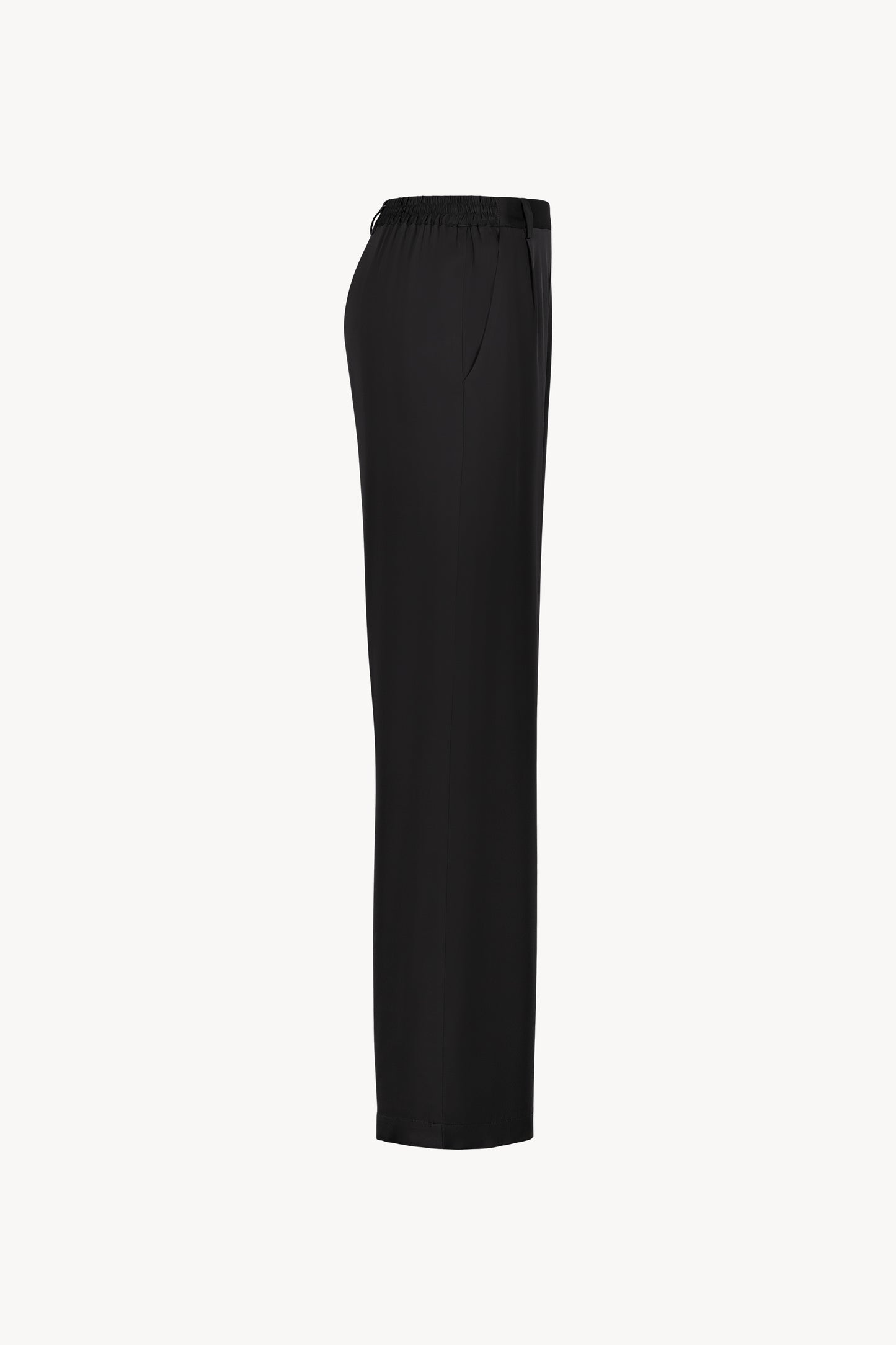 Pantalon en soie noir, avec une coupe droite et fluide qui souligne élégamment votre silhouette. Sa taille ajustée assure un confort optimal, tandis que les plis de presse marqués, les passants de ceinture et les revers aux chevilles ajoutent une touche sophistiquée.