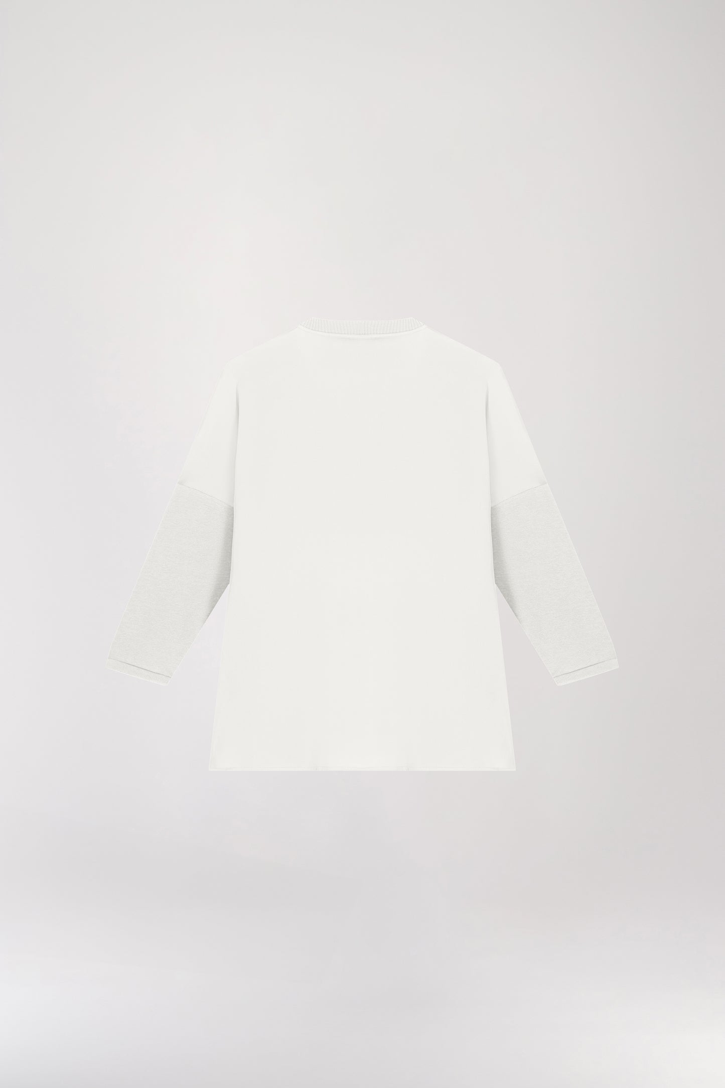 Tunique bi-matière jersey blanche, élégante et au look distingué, offrant un effet texturé qui sublime la silhouette. Avec des manches en jersey côtelé, un col côtelé et des fentes latérales, elle allie confort et sophistication.