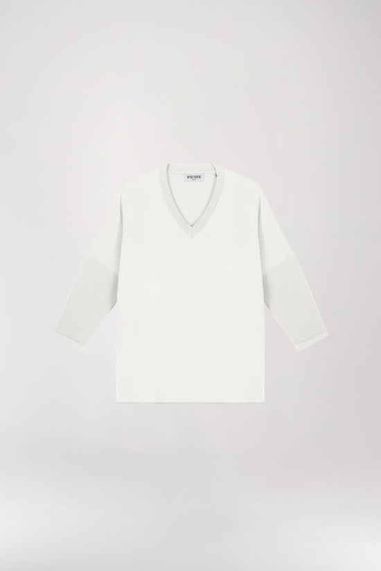 Tunique bi-matière jersey blanche, élégante et au look distingué, offrant un effet texturé qui sublime la silhouette. Avec des manches en jersey côtelé, un col côtelé et des fentes latérales, elle allie confort et sophistication.