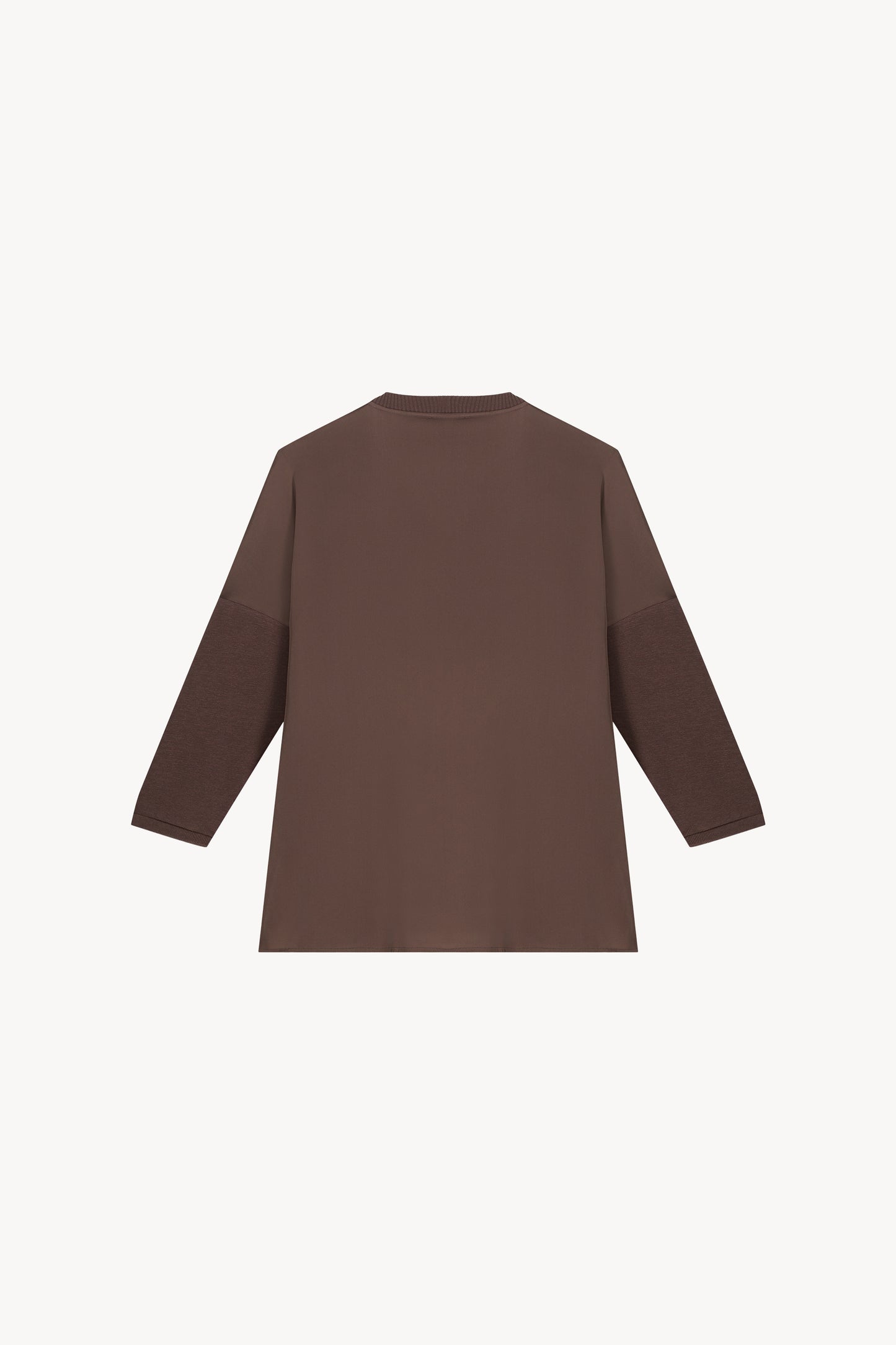 Tunique bi-matière jersey taupe, élégante et au look distingué, avec un effet texturé qui sublime la silhouette. Dotée de manches en jersey côtelé, d’un col côtelé et de fentes latérales, elle allie confort et sophistication.