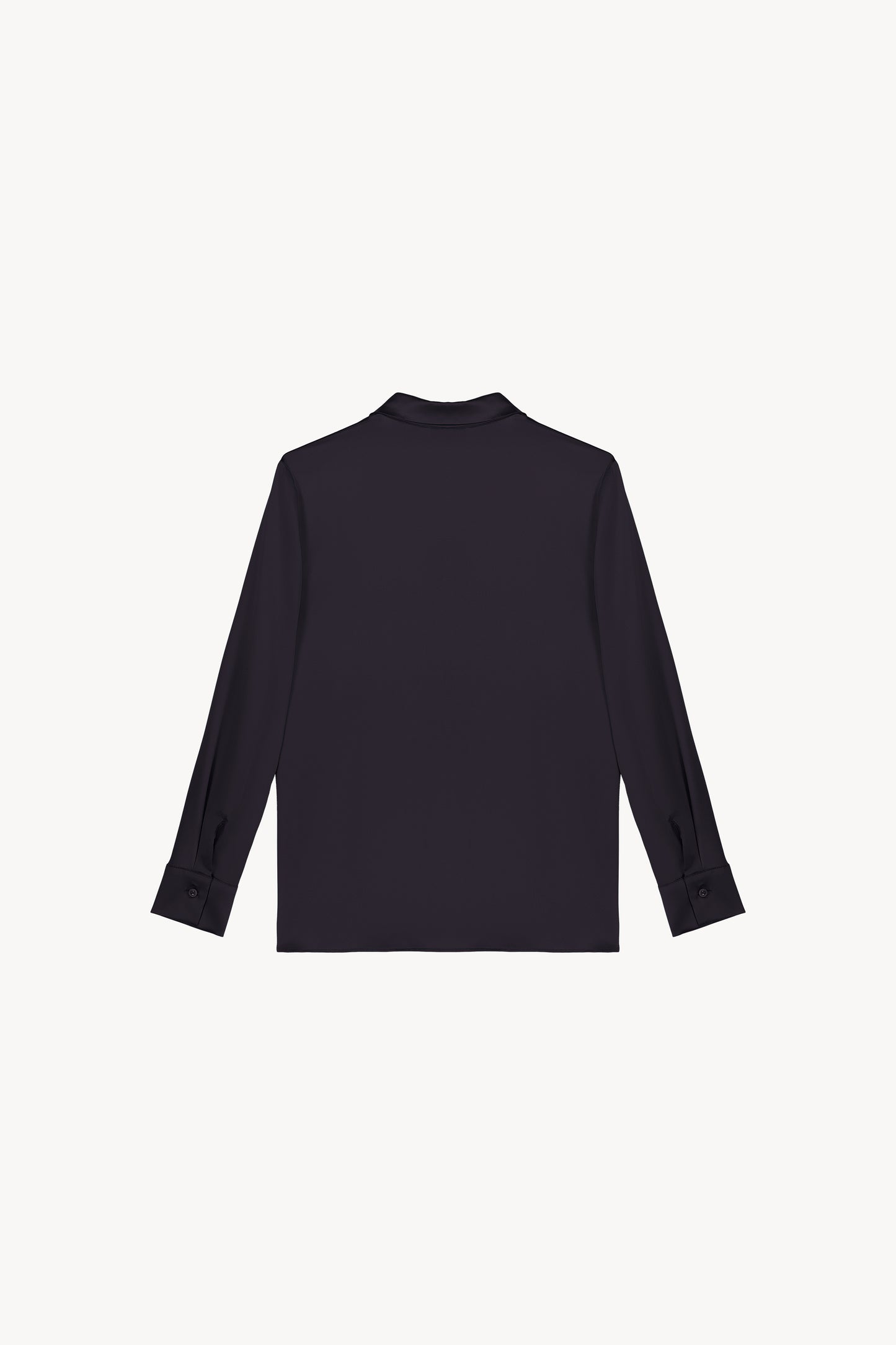 Chemise en satin de soie marine, resplendissante et rayonnante, incarnant l'élégance absolue. Sa coupe fluide et son tissu soyeux offrent une texture luxueuse, sublimée par une patte de boutonnage dissimulée, des fentes latérales discrètes et un ourlet arrondi en bas.
