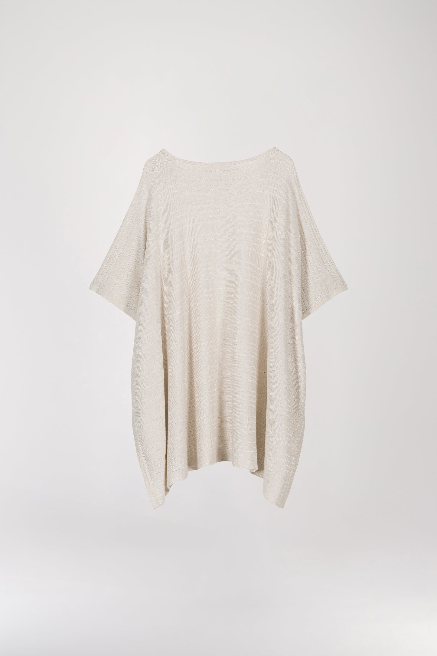 Pull poncho blanc cassé à coupe ample, orné de détails ajourés et de paillettes dorées pour une touche minimaliste. Son col arrondi ajoute une note de féminité à ce modèle élégant.