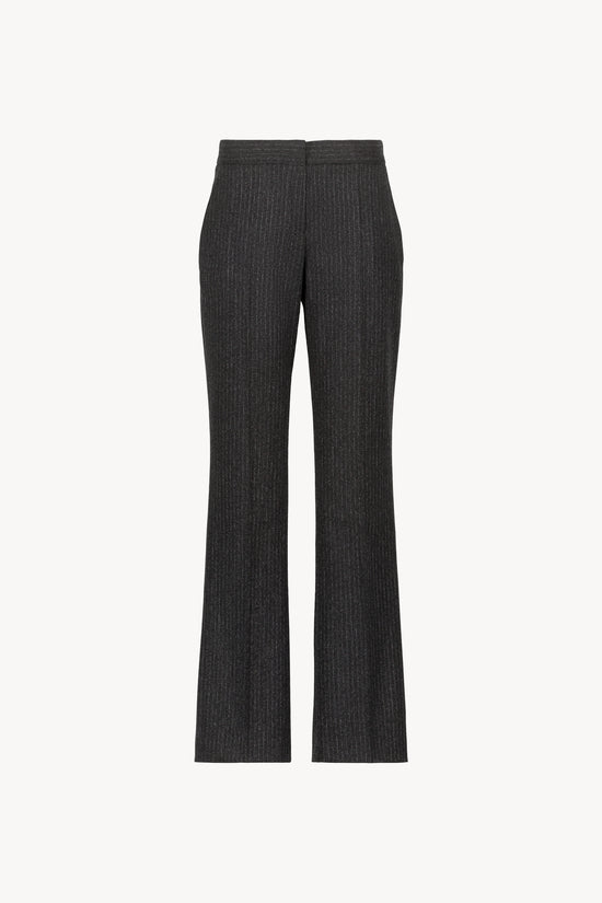 Pantalon droit gris moyen revisite l’élégance classique avec ses plis marqués et ses rayures blanches. 