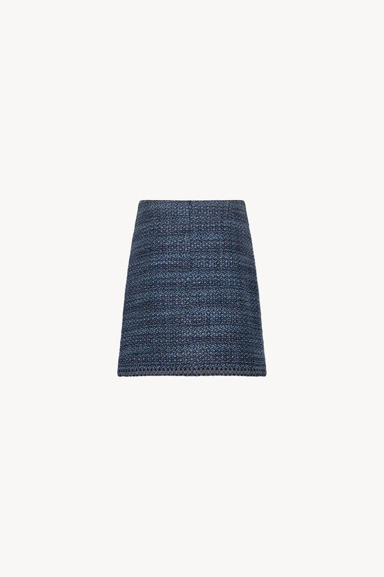 Jupe en tweed bleu denim avec piping en daim et boutons brodés. 
