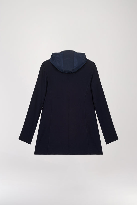 Veste trompe-l'œil marine ornée d'une capuche amovible, offrant la flexibilité de l'adopter ou de l'ôter pour ajuster votre allure selon votre style du moment. Col tailleur en laine par-dessus, qui dépasse sur le col, simple boutonnage, poches plaquées, détails en velours sur les poches, capuche à zip intégrée et amovible.