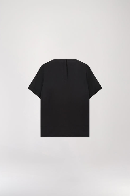 T-shirt en soie noir doté d'un col rond, d'une fermeture à bouton dans le dos, et d'une forme goutte à l'arrière, il présente un bouton recouvert pour une touche délicate.