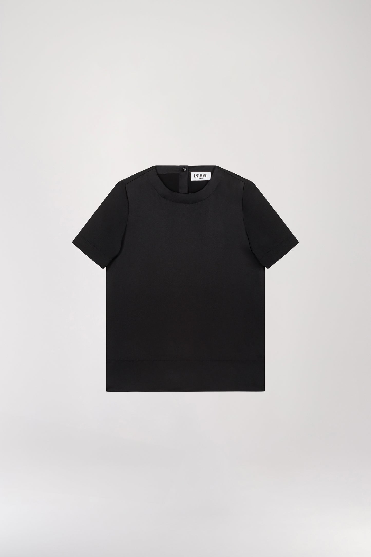 T-shirt en soie noir doté d'un col rond, d'une fermeture à bouton dans le dos, et d'une forme goutte à l'arrière, il présente un bouton recouvert pour une touche délicate.