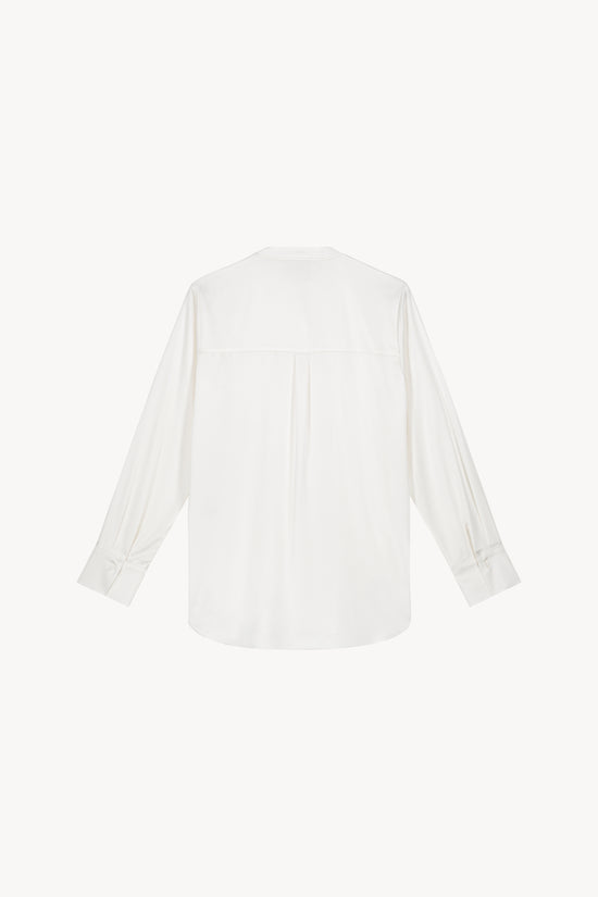 Chemise sans col blanc cassé ornée d'une coupe fluide et soyeuse, d'un col officier, d'une patte de boutonnage cachée et de détails froncés au dos.