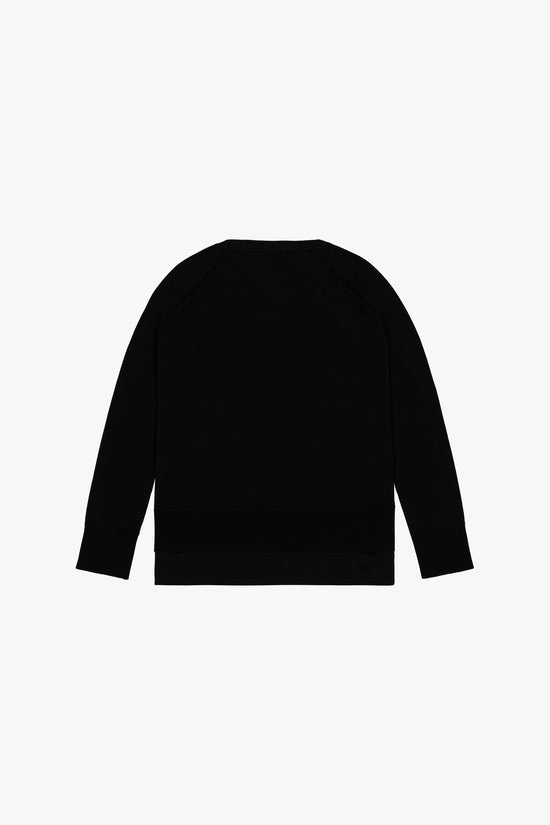 Cette maille noire en laine, à la coupe décontractée et effet trompe-l'œil.