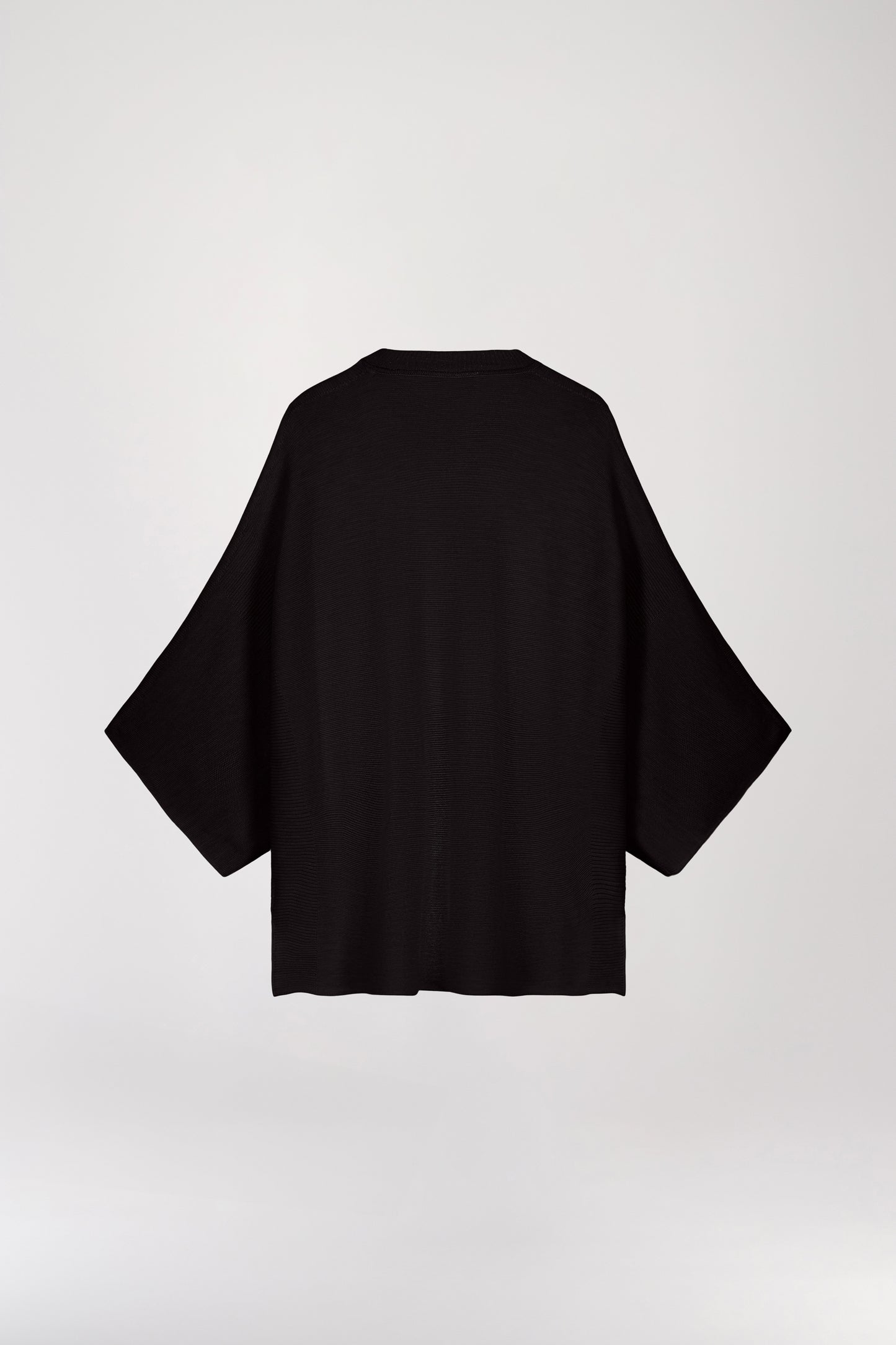 Pull poncho en laine noire, avec une coupe ample oversize, des manches 3/4 et un col rond côtelé.