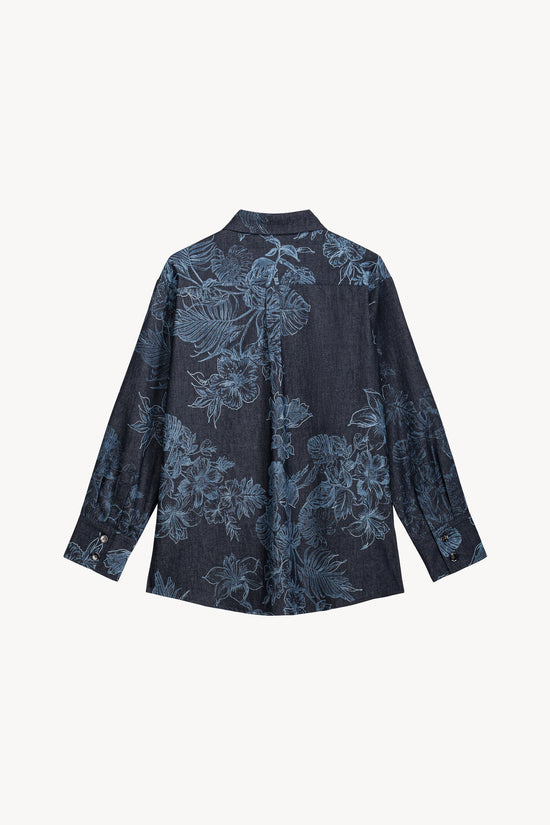 Cette chemise en denim révèle un jeu de contrastes subtils entre le motif floral et les finitions soignées.
