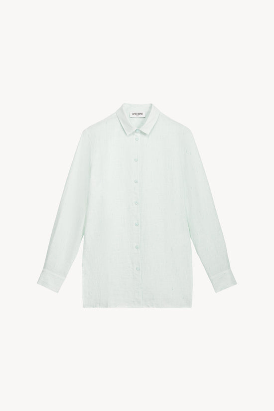 Une chemise en lin vert d’eau au tombé fluide et aux rayures subtiles.