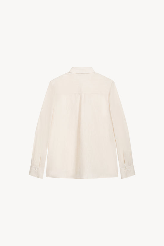 Confectionnée dans un esprit contemporain, cette chemise militaire au boutonnage nacré blanc cassé.