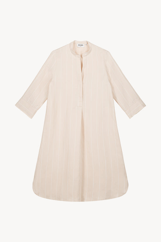Robe mi-longue beige, avec son col officier ouvert et ses détails soignés.