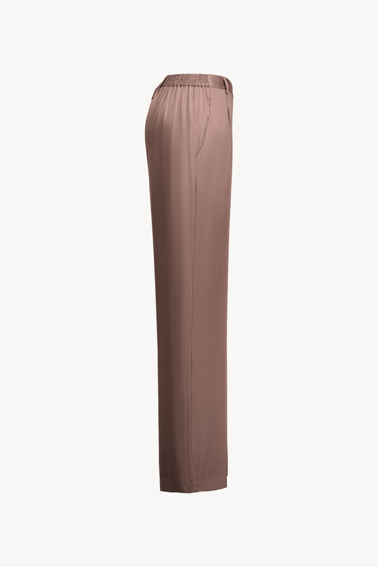 L'élégance discrète de ce pantalon droit en georgette de soie stretch, dans une nuance raffinée de marron glacé, se distingue par sa coupe impeccable.