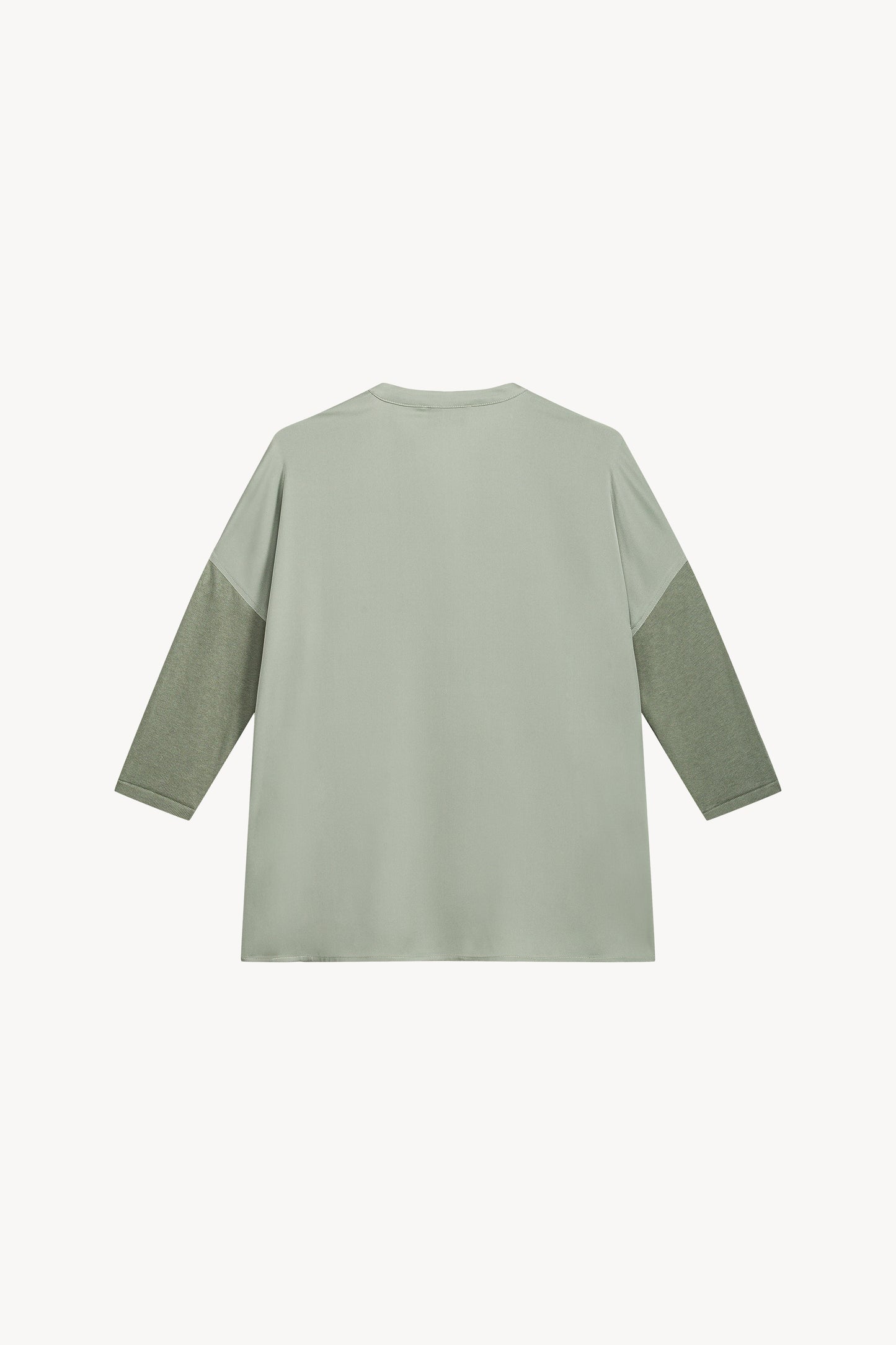 Ce modèle bi-matière sauge, avec son col en V et ses manches en jersey, allie élégance et raffinement.