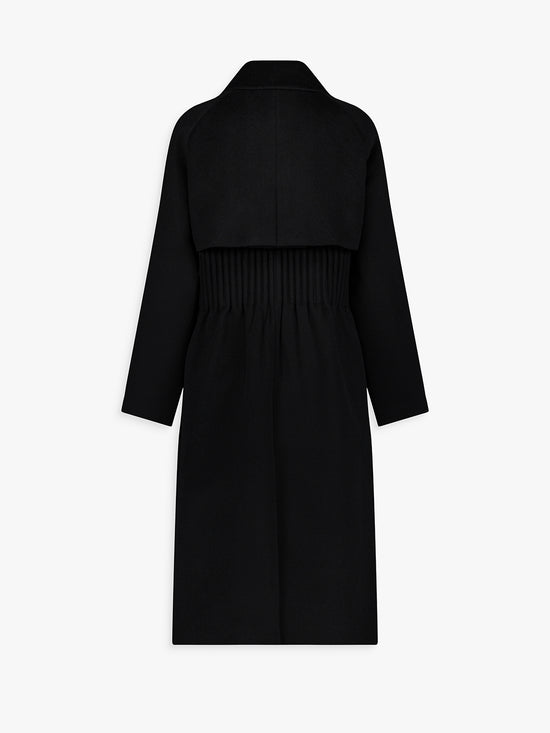 Dos du manteau noir en laine, plis élégants et tombé fluide.