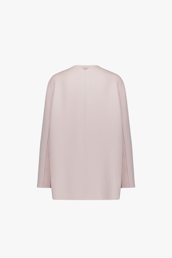 Dos du manteau rose pâle, ligne fluide et épurée.