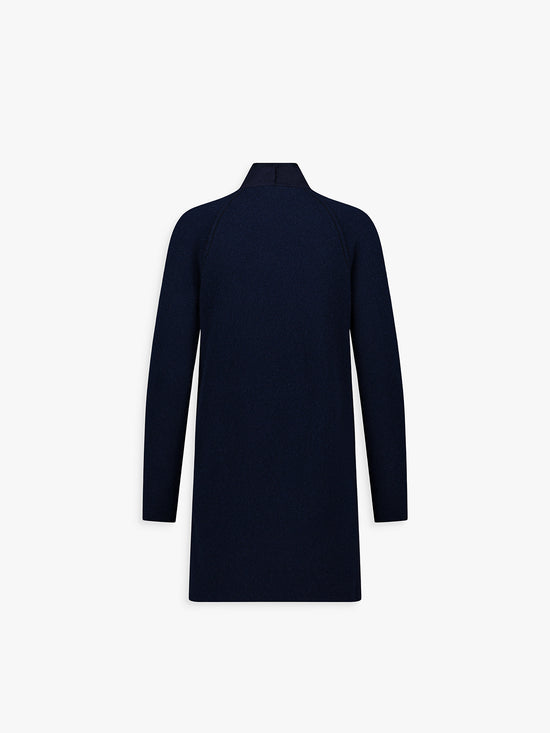 Dos du manteau ample bicolore, lignes souples et tombé fluide.