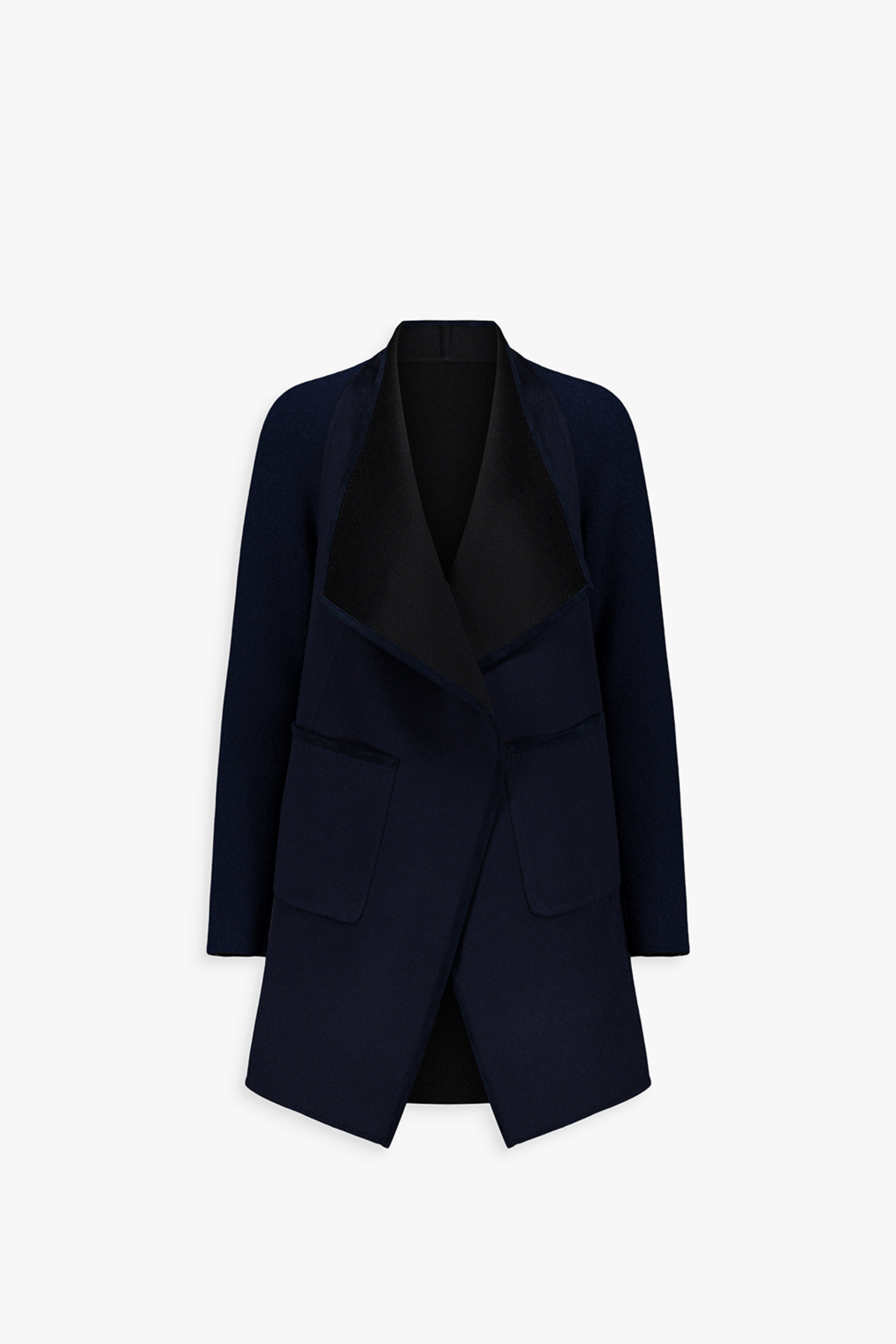 Dos du manteau ample bicolore, lignes souples et tombé fluide.