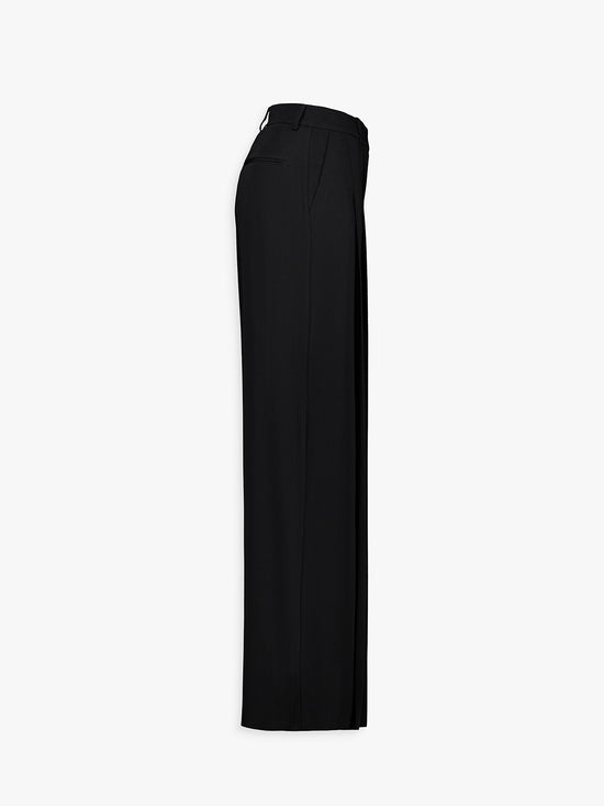 Pantalon ample noir porté, silhouette élégante et équilibrée.