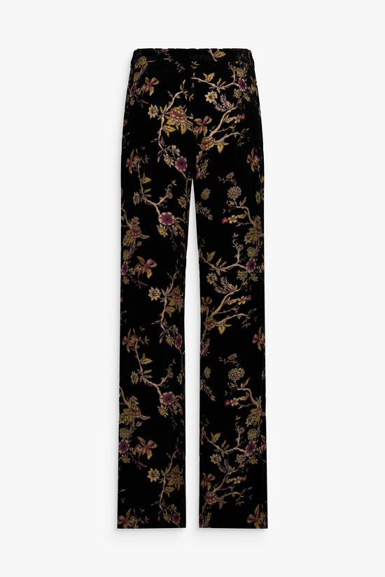 Pantalon en velours de soie noir à motifs floraux porté.