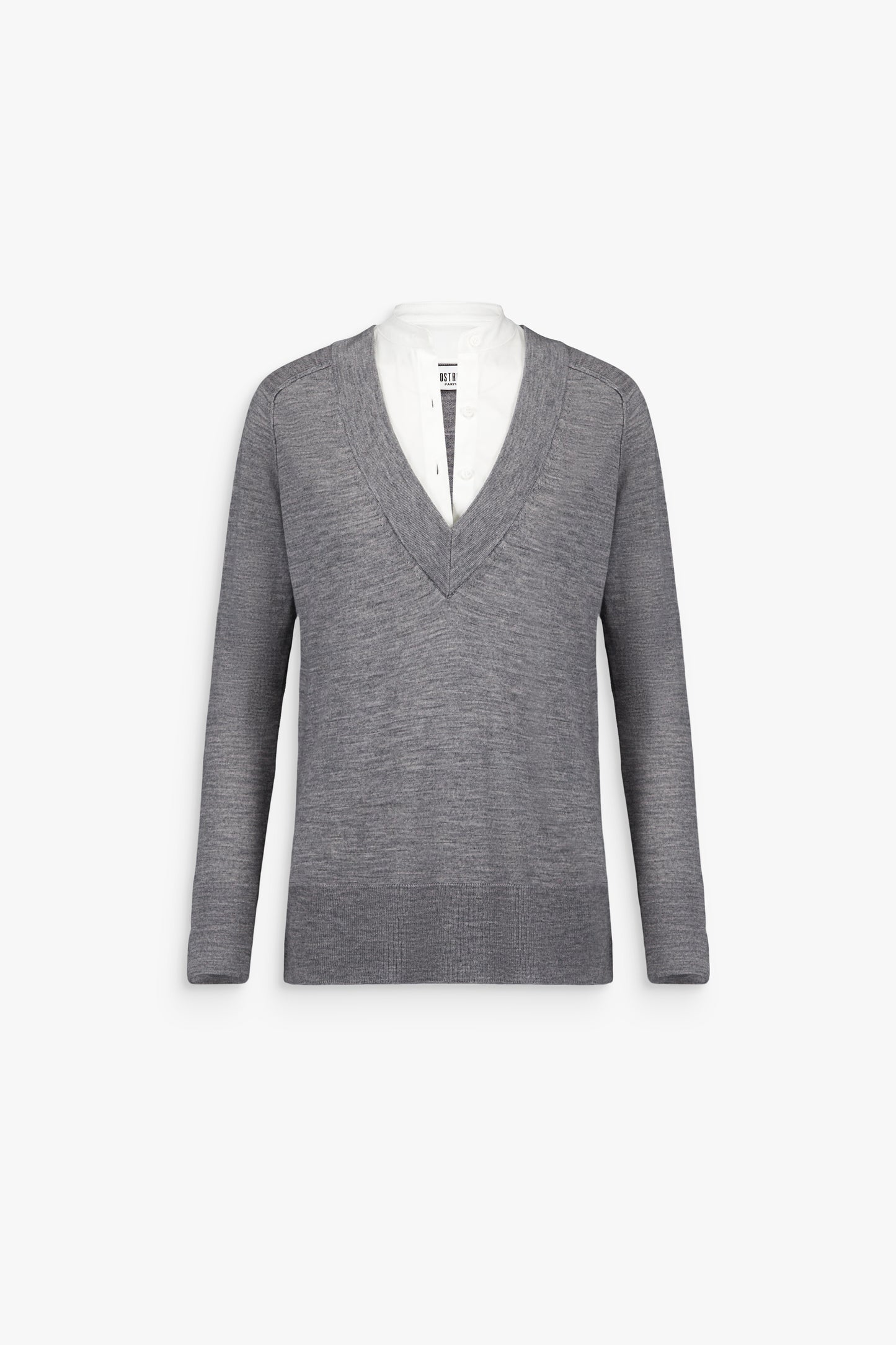 Femme portant un pull gris moyen trompe-l’œil, laissant apparaître une bande de popeline blanche au col.