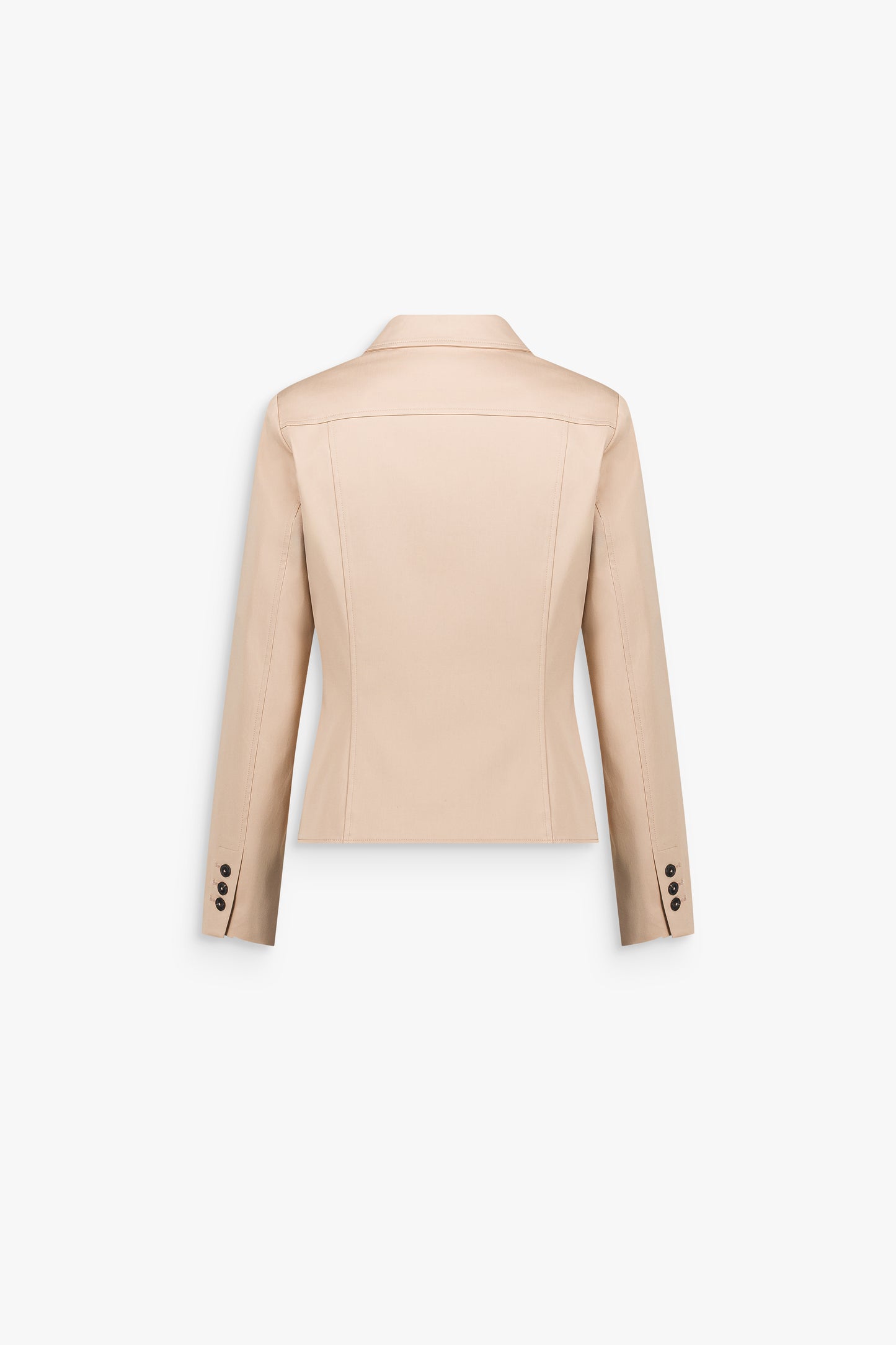 Détail d’une veste beige en satin de coton au fini lisse et lumineux, structurée par une ligne épurée.