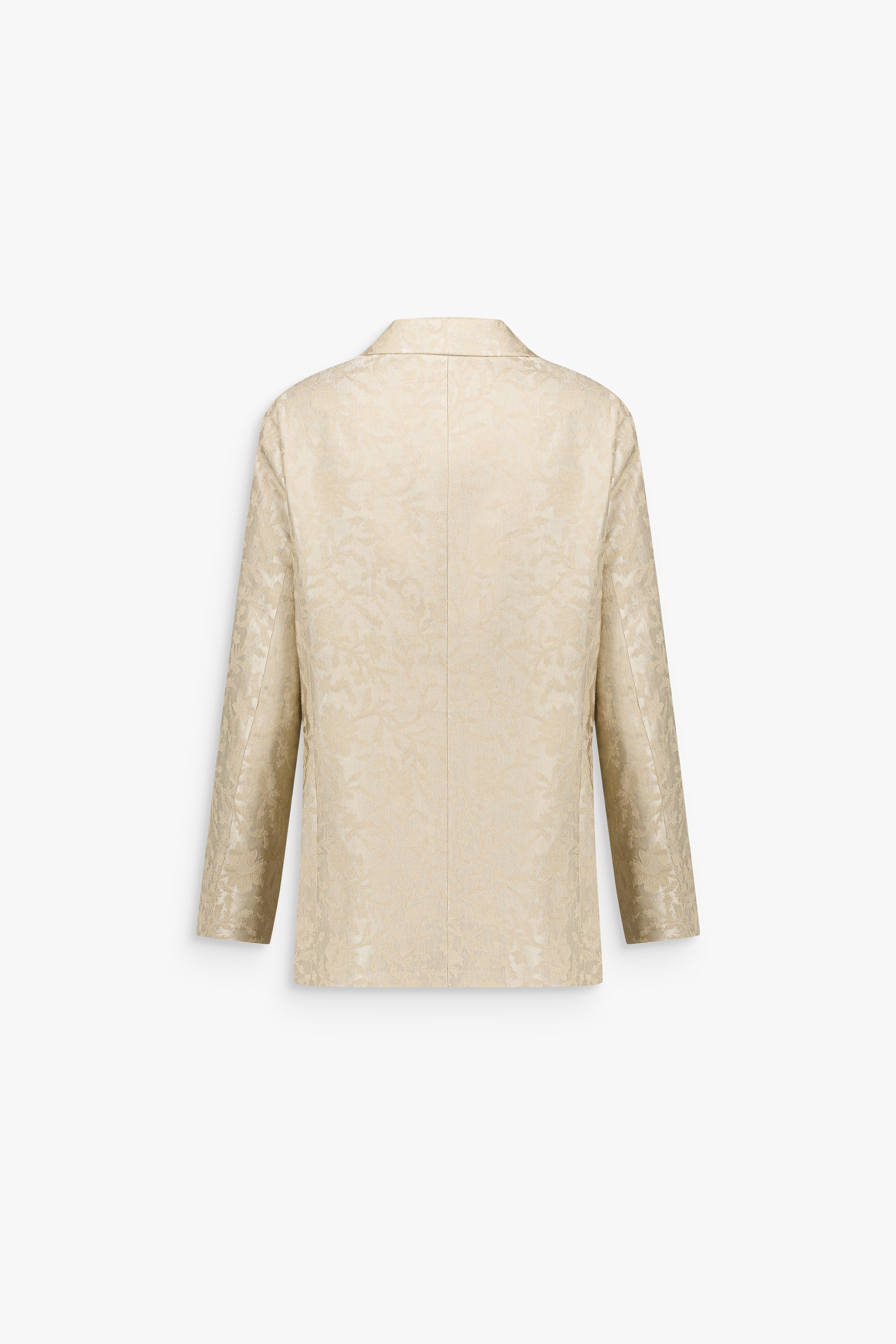 Détail d’une veste en jacquard de lin texturé, révélant un motif floral discret