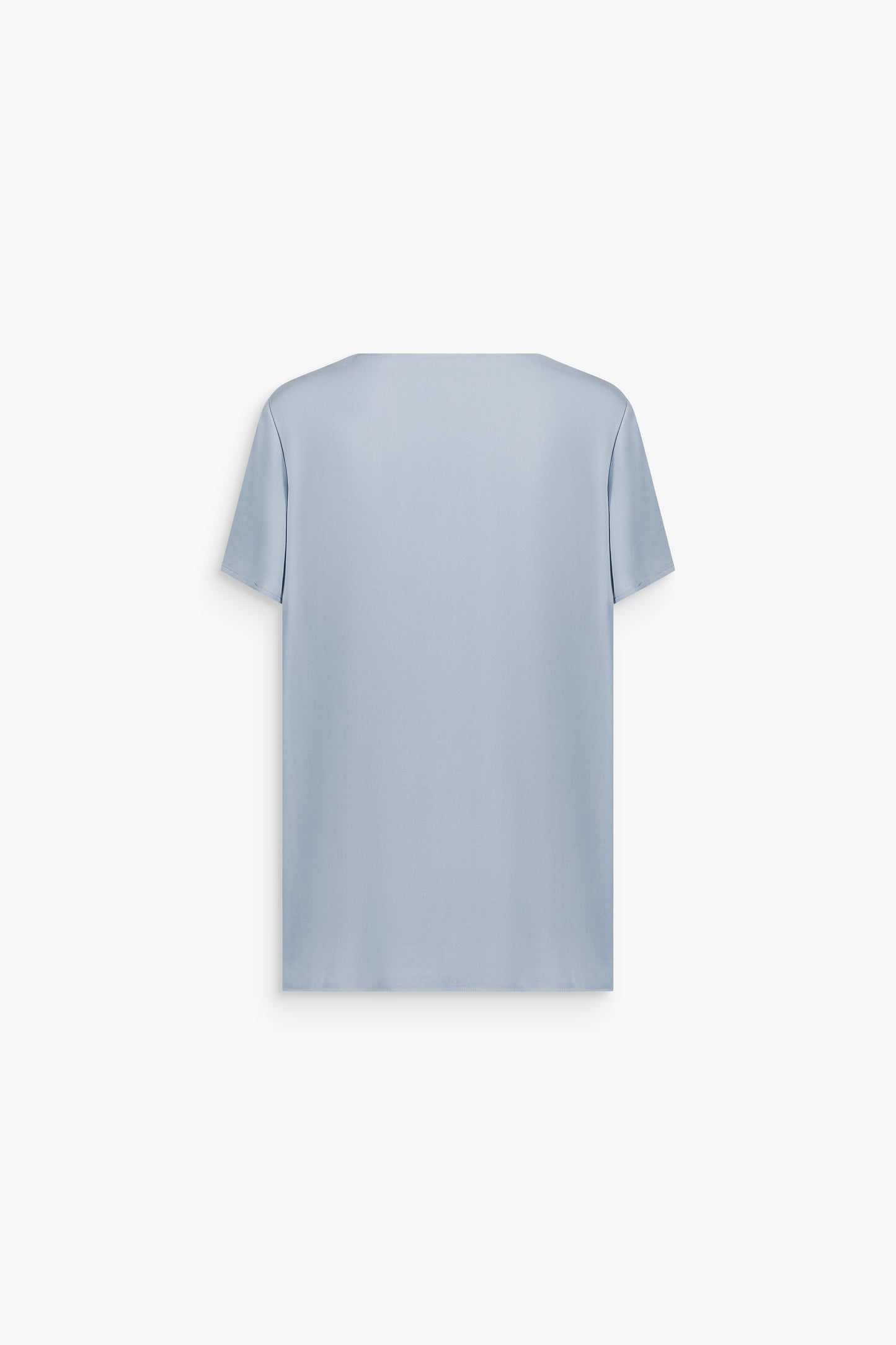 Blouse minimaliste bleu denim avec manches courtes et ligne épurée.