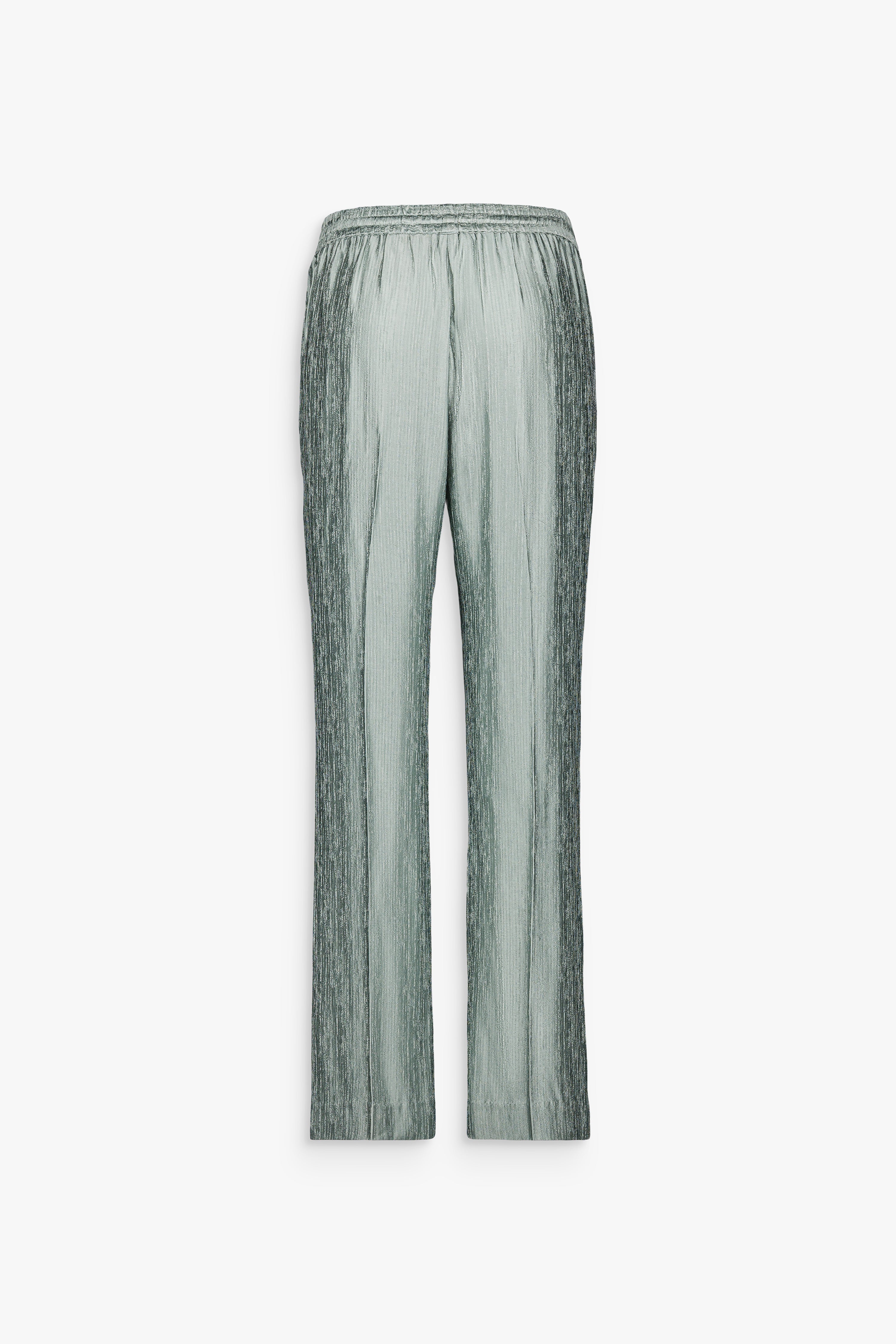 Pantalon fluide vert sauge avec taille élastiquée et finitions métalliques gravées.