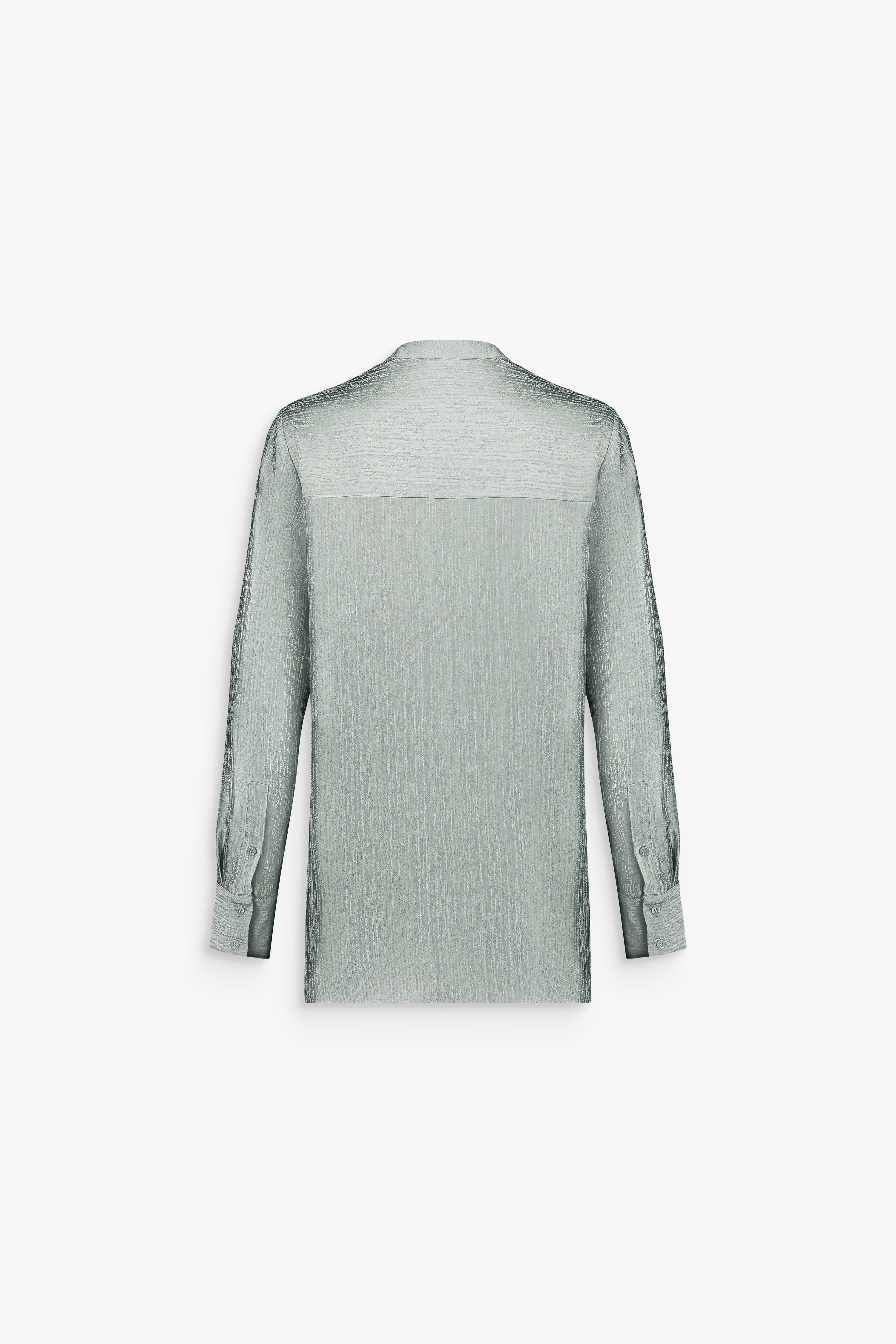 Tunique femme couleur sauge à texture subtile avec col ouvert et coupe élégante.