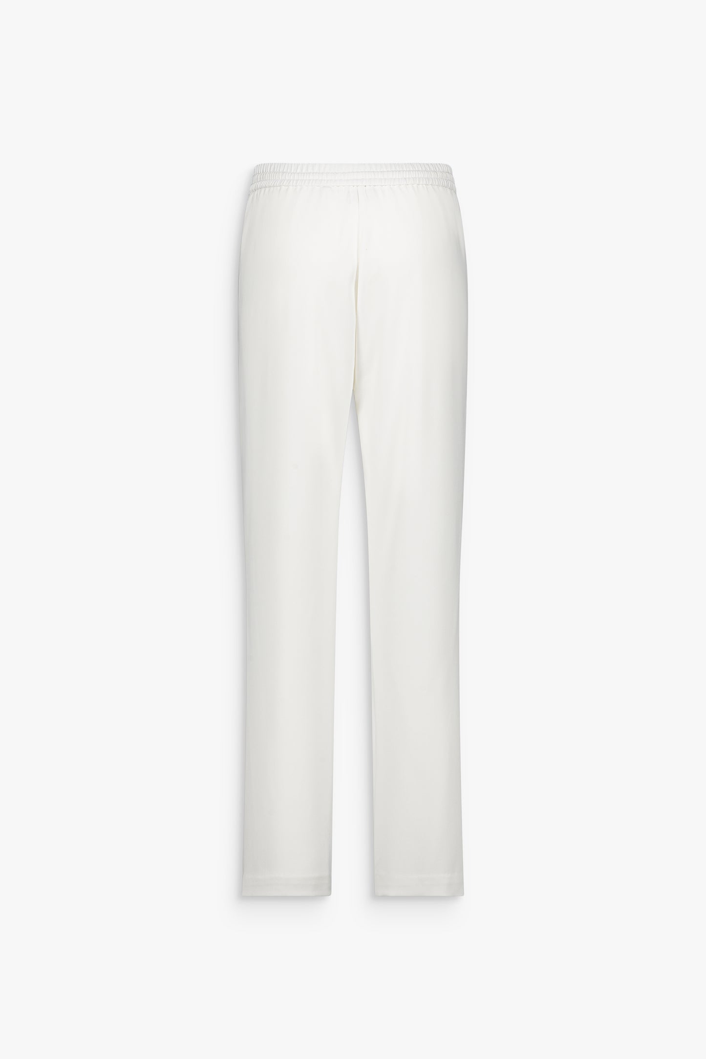Détail gusset structurant sur pantalon blanc cassé à la construction minimaliste.