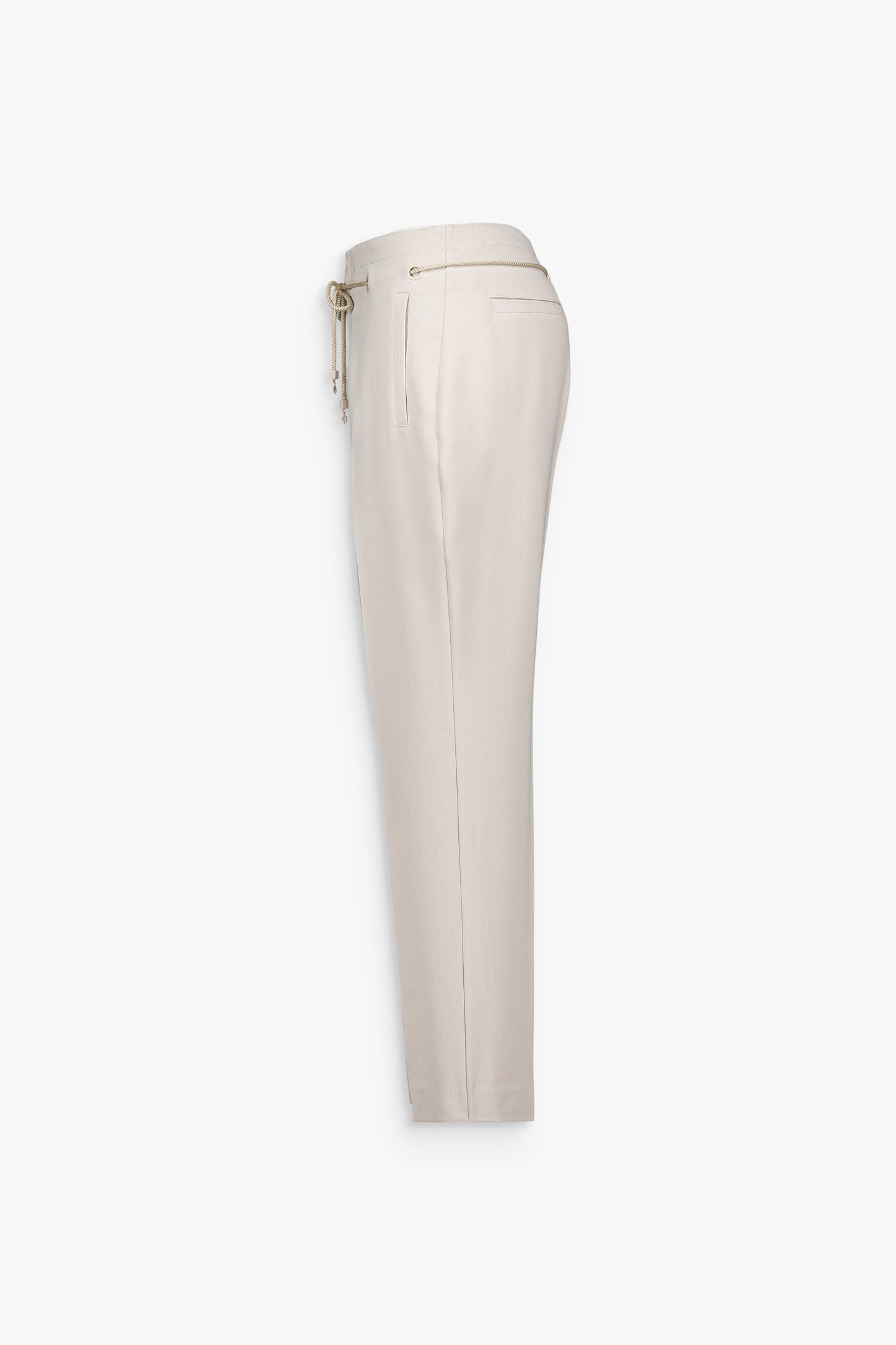 Plis marqués sur le devant du pantalon beige soulignant la verticalité de la coupe.