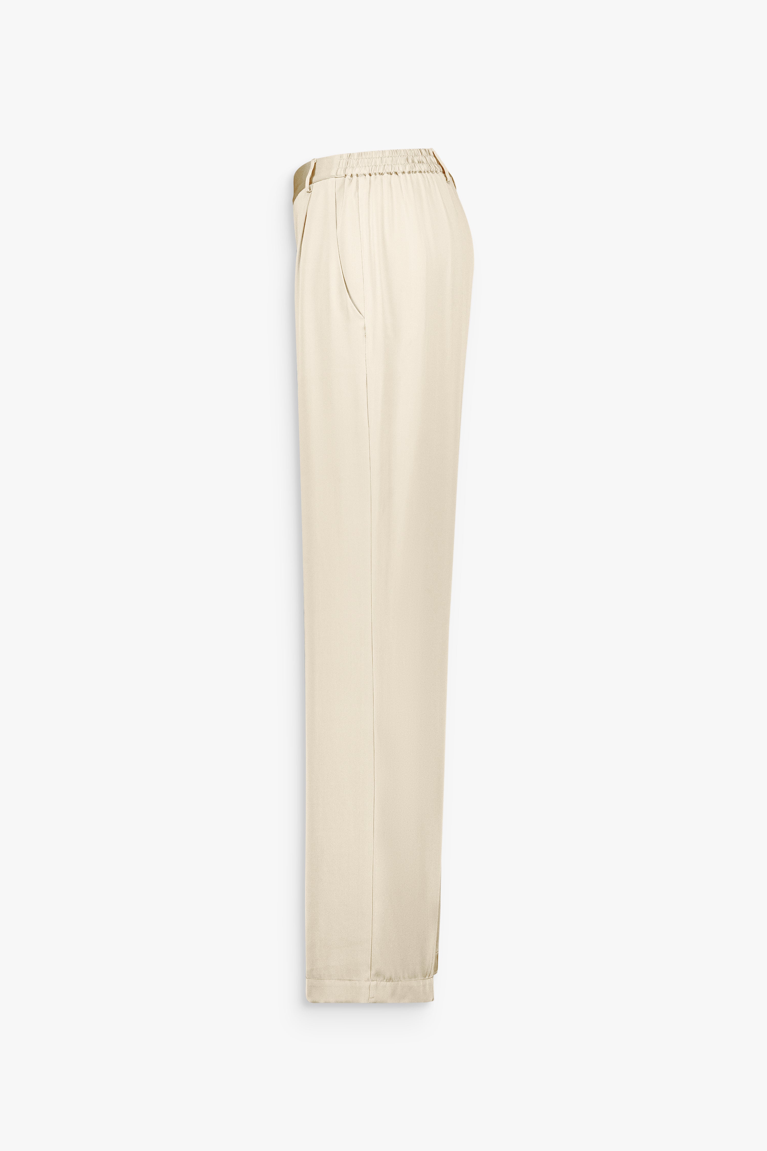 Poche italienne sur pantalon droit en soie jaune clair à la coupe épurée.