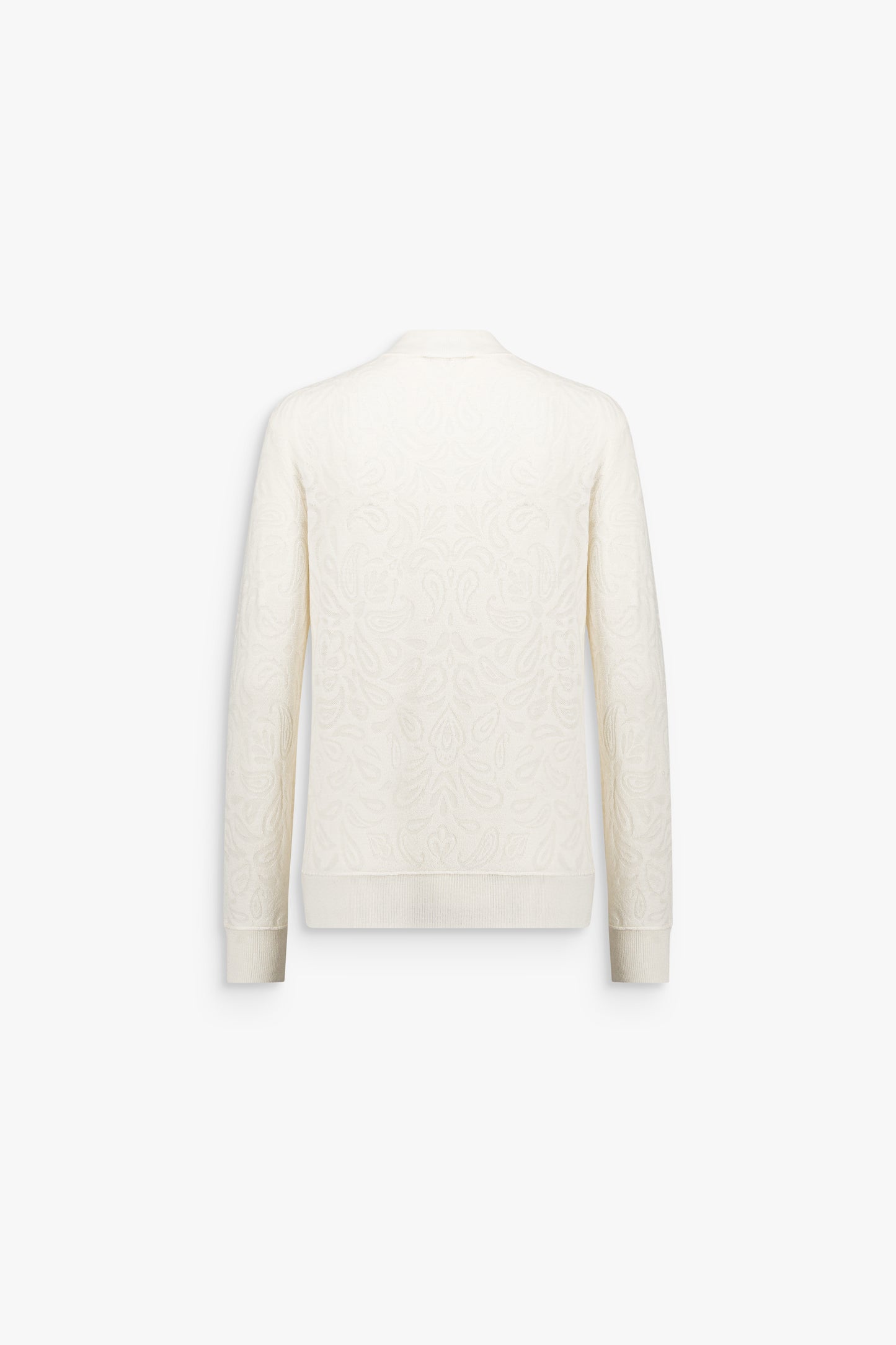 Détail d’un pull en maille fine blanc cassé, à coupe droite légèrement ample et motif graphique discret.