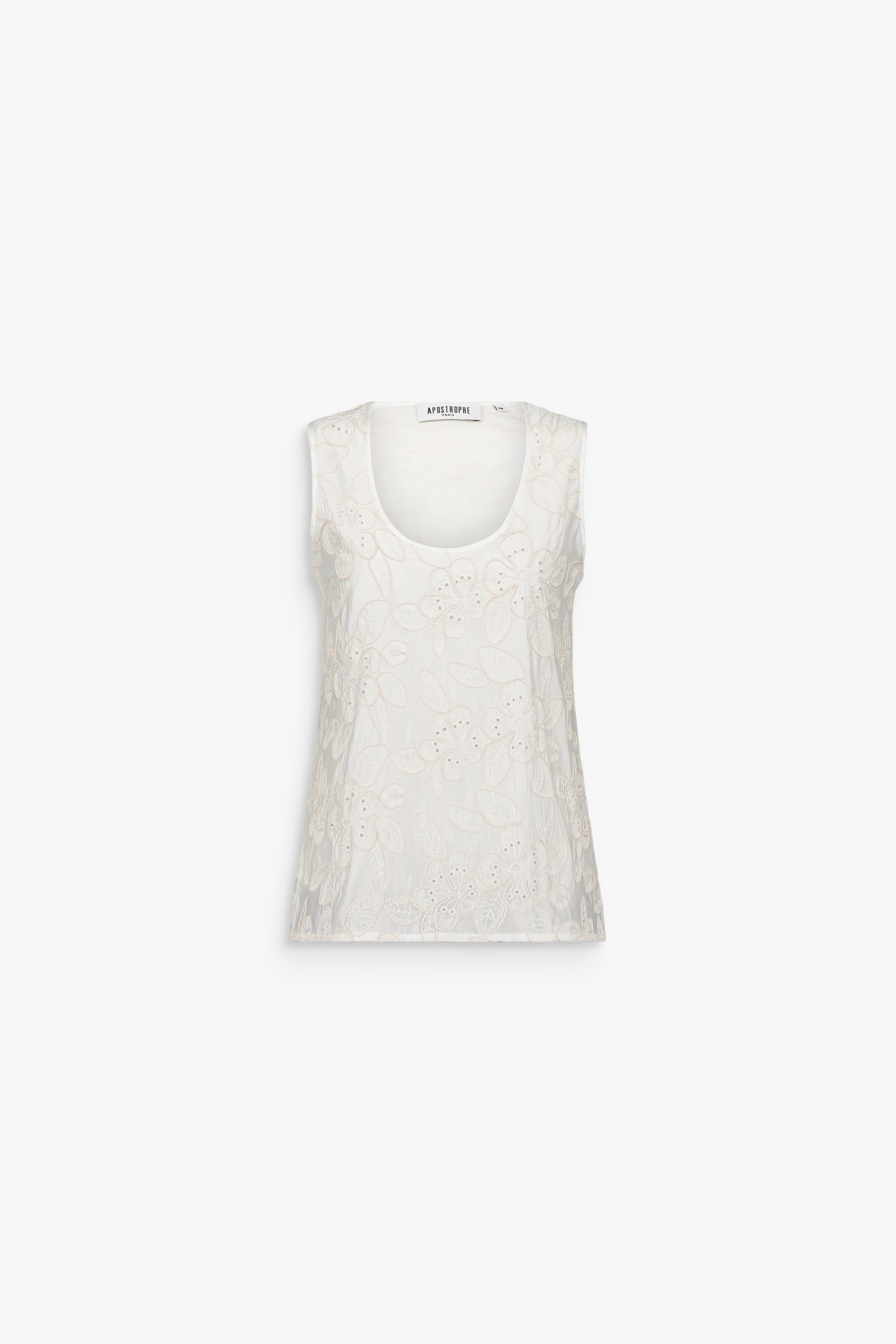 Top blanc cassé sans manches avec motif floral ton sur ton et encolure ronde.